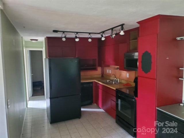 kitchen with light tile patterned floors, track lighting, sink, and black appliances