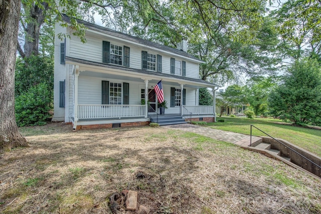 view of front of home with covered porch, crawl space, a front yard, and a chimney