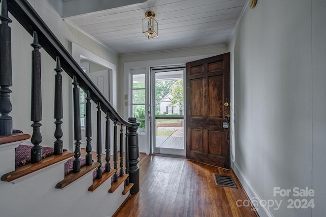 foyer entrance with stairway, wood finished floors, visible vents, and crown molding