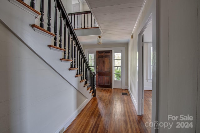 entryway featuring baseboards, stairs, visible vents, and dark wood finished floors