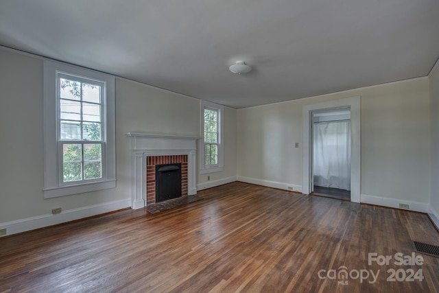 unfurnished living room featuring baseboards, a fireplace, visible vents, and dark wood finished floors