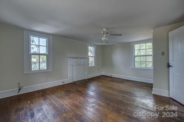 unfurnished living room featuring dark wood-type flooring, a ceiling fan, and baseboards