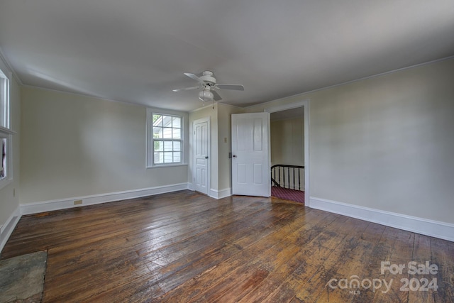 unfurnished room featuring dark wood-style floors, baseboards, and a ceiling fan