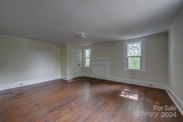 spare room featuring dark wood-style flooring and baseboards