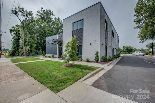 view of side of property with a lawn and brick siding