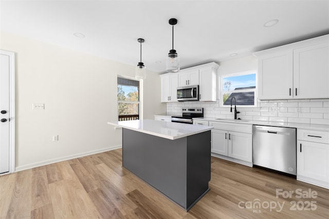 kitchen featuring a center island, sink, white cabinets, and appliances with stainless steel finishes