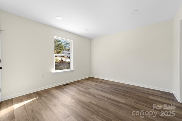 unfurnished room with hardwood / wood-style flooring