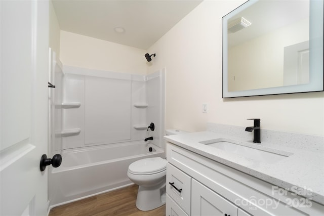 full bathroom featuring shower / bathing tub combination, hardwood / wood-style floors, vanity, and toilet