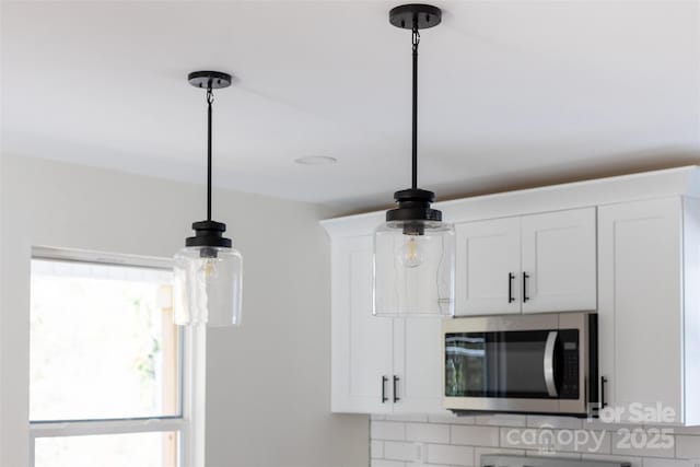 room details with pendant lighting, white cabinetry, and tasteful backsplash