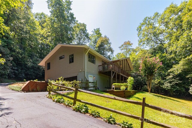 view of property exterior featuring a lawn and a wooden deck