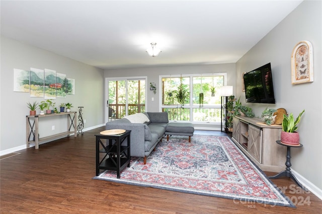 living area with baseboards and wood finished floors