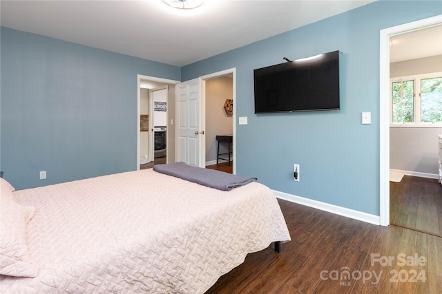 bedroom featuring washer / dryer, baseboards, and dark wood-style floors