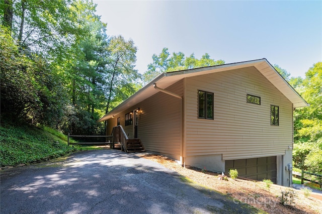 view of side of home featuring a garage and driveway