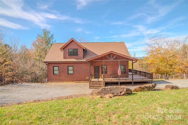 log home featuring a front yard and covered porch