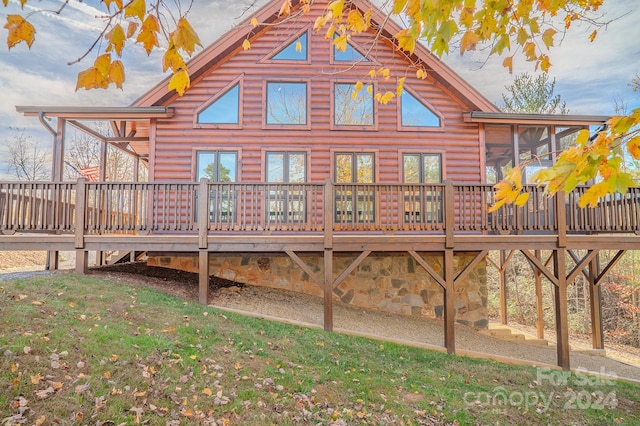 rear view of property featuring a sunroom and a deck