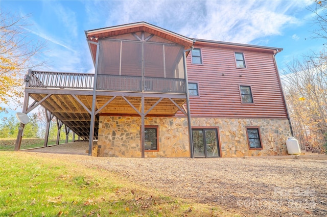 rear view of property featuring a deck and a sunroom