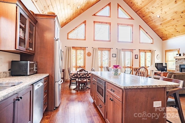 kitchen featuring appliances with stainless steel finishes, wood ceiling, a breakfast bar, high vaulted ceiling, and dark hardwood / wood-style floors