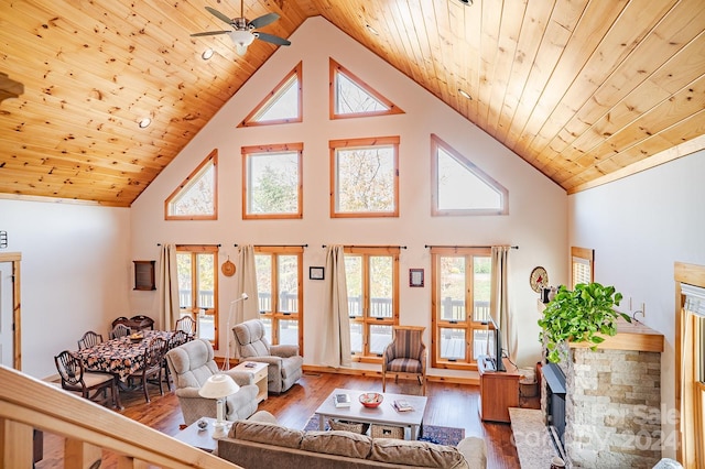 living room with high vaulted ceiling, a wealth of natural light, and wooden ceiling