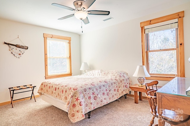 carpeted bedroom with multiple windows and ceiling fan