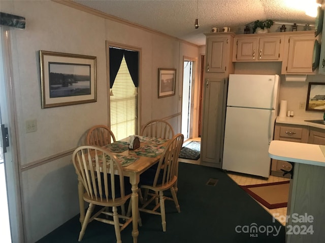 dining space with a textured ceiling and crown molding