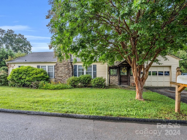 view of front of property featuring a front yard and a garage