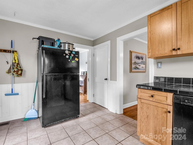 kitchen featuring black appliances, light hardwood / wood-style flooring, and ornamental molding