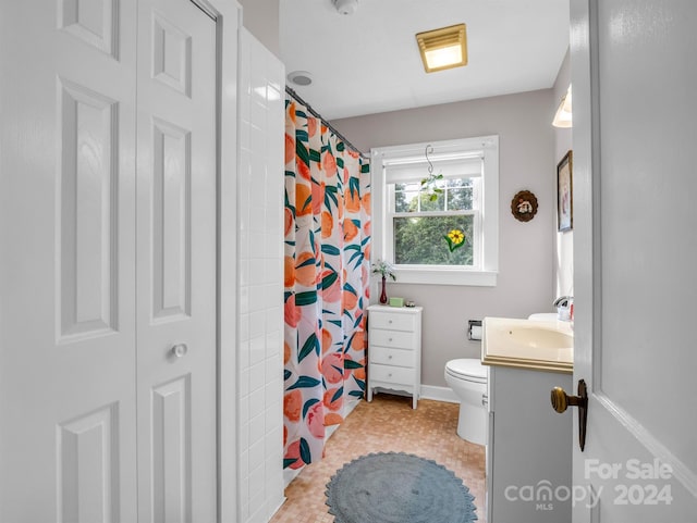 bathroom featuring toilet, vanity, and tile patterned flooring