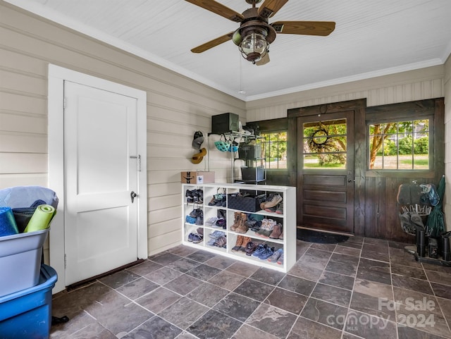 mudroom featuring ceiling fan, wood walls, dark tile patterned floors, and ornamental molding