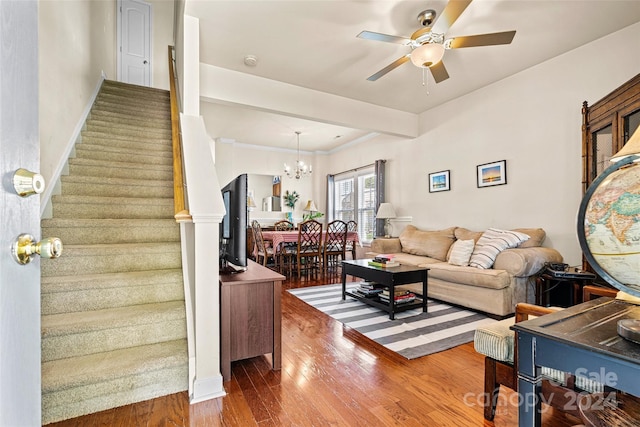 living room with ceiling fan with notable chandelier and hardwood / wood-style flooring