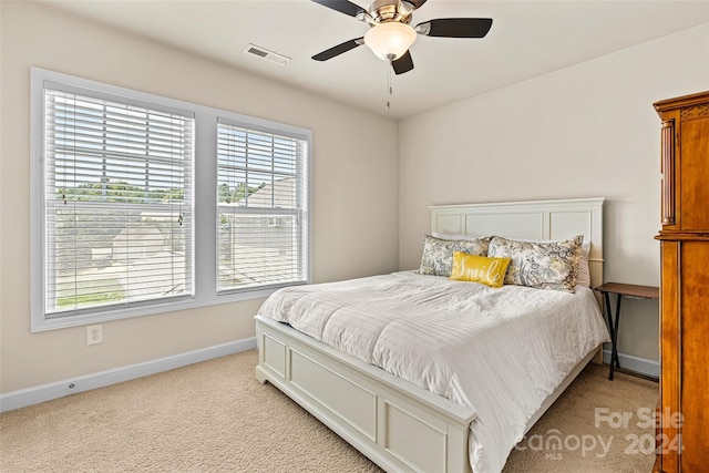 carpeted bedroom with ceiling fan and multiple windows