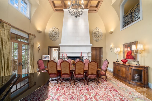 dining space featuring a high ceiling, coffered ceiling, beam ceiling, and french doors