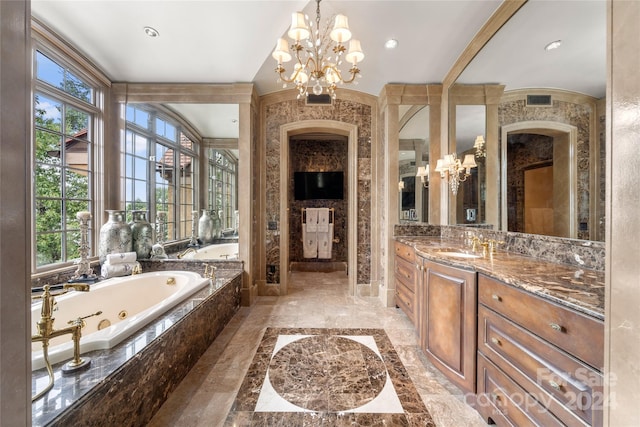 bathroom featuring a chandelier, marble finish floor, a jetted tub, and vanity