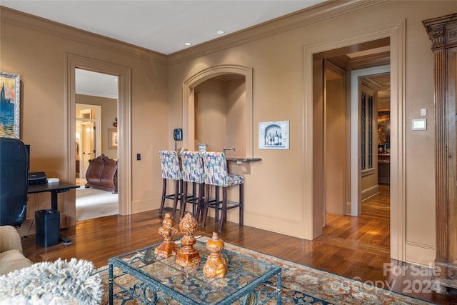 living room featuring dark wood-style floors, ornamental molding, and baseboards