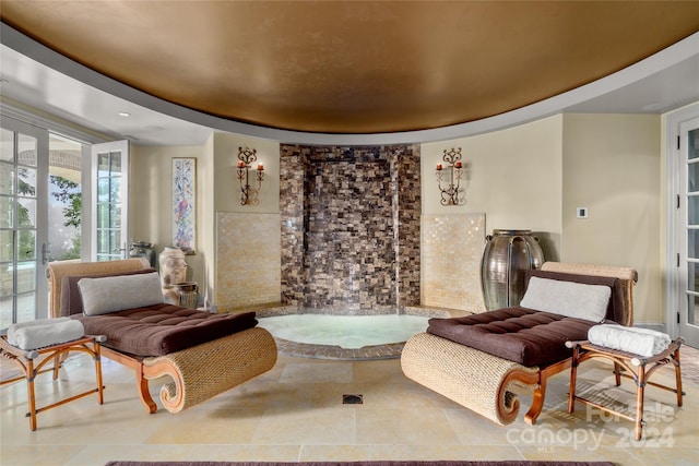 sitting room with tile patterned flooring, a raised ceiling, and french doors