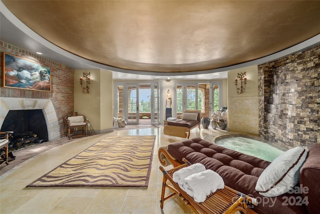 interior space featuring a tray ceiling, french doors, and a high end fireplace