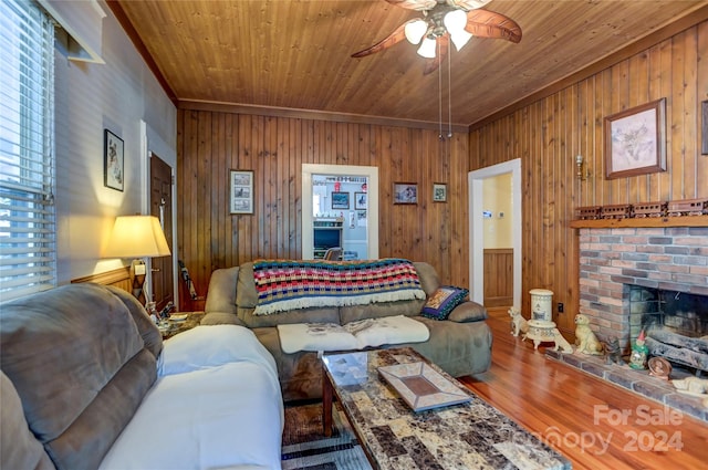 living room with wood walls, a fireplace, wood-type flooring, ceiling fan, and wood ceiling