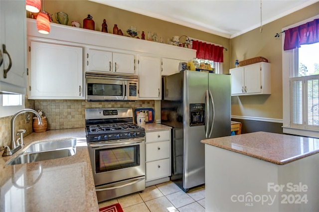 kitchen featuring backsplash, stainless steel appliances, white cabinetry, sink, and light tile patterned flooring