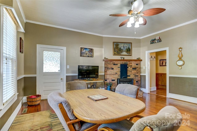 dining room with a healthy amount of sunlight, wood-type flooring, and a wood stove