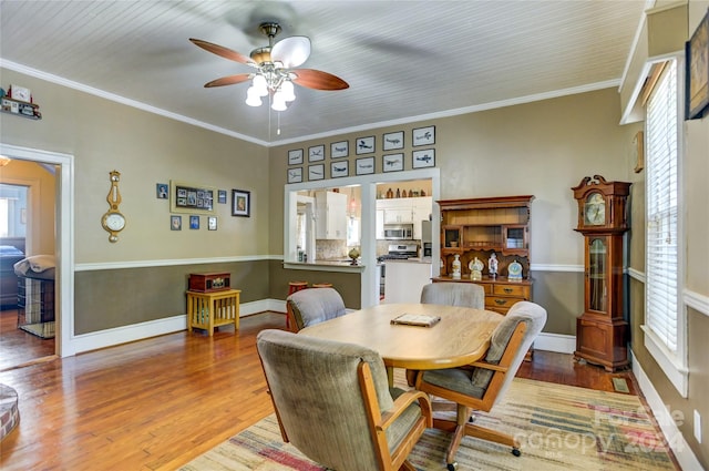 dining space featuring ceiling fan, ornamental molding, and wood-type flooring