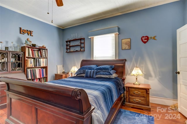 bedroom featuring ceiling fan, crown molding, and hardwood / wood-style floors