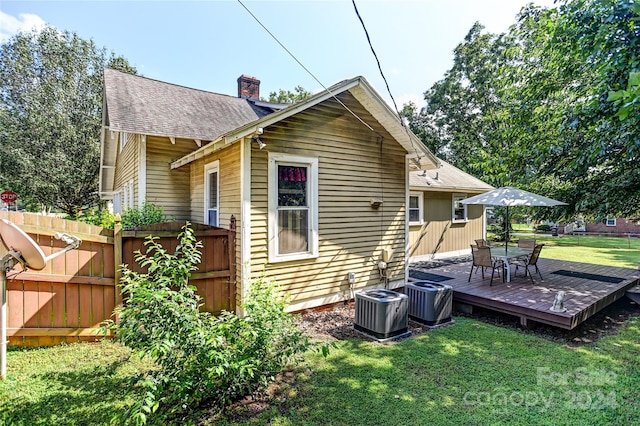 rear view of house with a lawn, central AC unit, and a deck