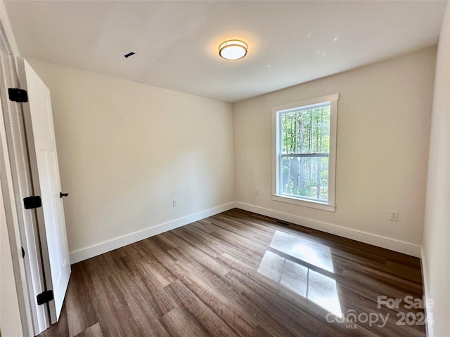 spare room with dark wood-type flooring