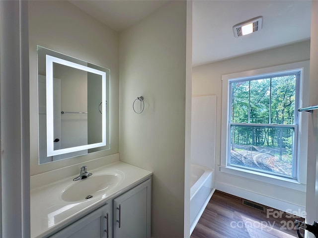 bathroom featuring hardwood / wood-style flooring, vanity, and shower / tub combination