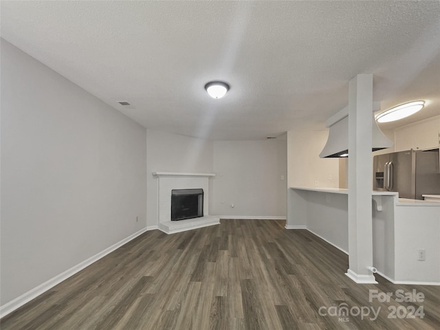 unfurnished living room featuring a textured ceiling and hardwood / wood-style floors