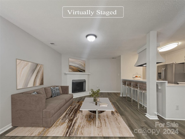 living room featuring dark hardwood / wood-style floors and a textured ceiling