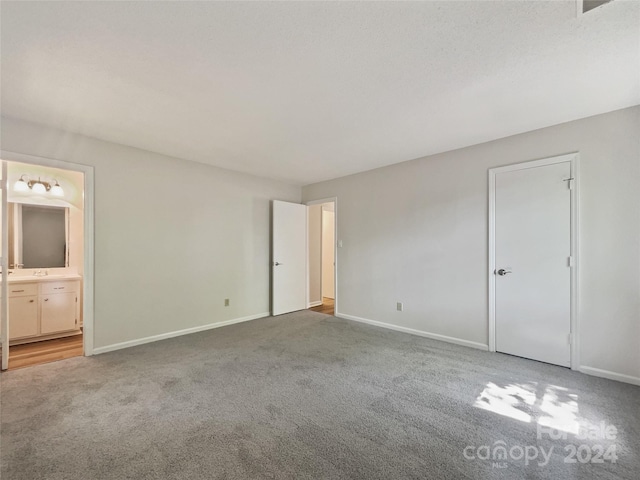 unfurnished bedroom with carpet flooring and ensuite bath