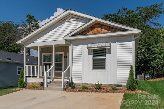 view of front of home with covered porch and central AC