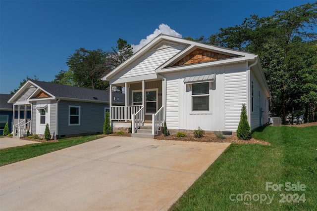 view of front of home with central AC and a front yard