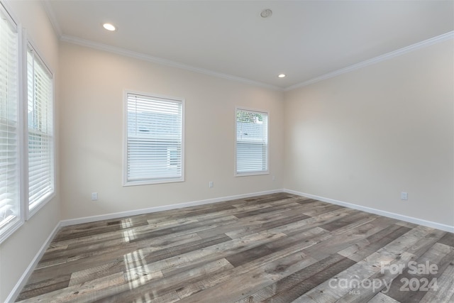 spare room with ornamental molding, hardwood / wood-style floors, and a healthy amount of sunlight