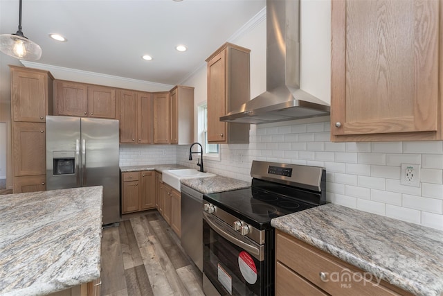 kitchen with sink, hardwood / wood-style flooring, wall chimney exhaust hood, tasteful backsplash, and stainless steel appliances